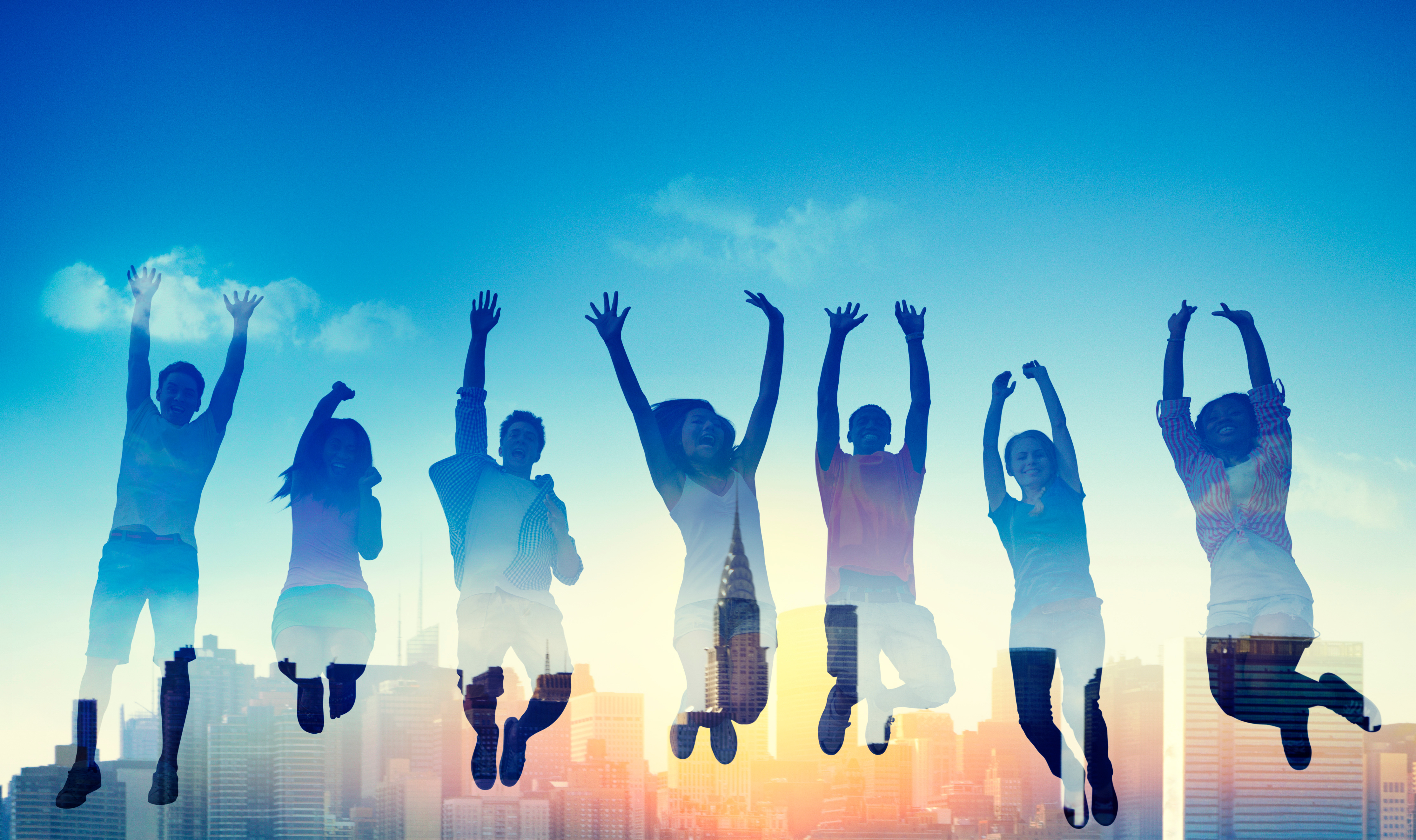 smiling adolescents jump in air together at sunset